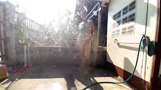 GARDEN SHOWER AND WATER RUBS INTO RURAL GARDEN a Man