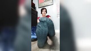 Removes blue velveteen boots and thick grey stockings on rainy day