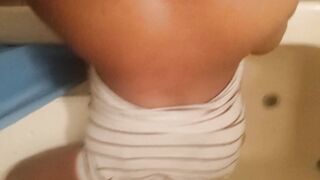 Bent over inside the bath-tub