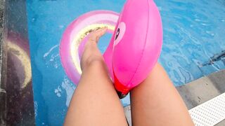 HAVING FUN WITH THE TOES ON THE SIDE OF THE POOL WITH THE BUOY