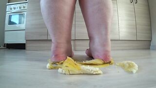 a long mature woman, bbw, smash a banana with bare feet, heels.