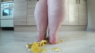 a long mature woman, bbw, smash a banana with bare feet, heels.