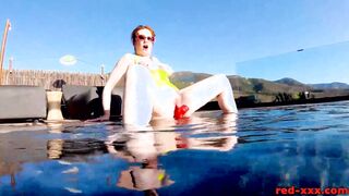 Red XXX fucks her cunt with a sex toy into the pool