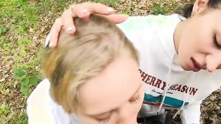 Two Girlfriends Suck Cock in the Wood