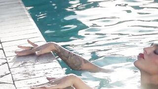 Glamorous naked babe posing by the pool
