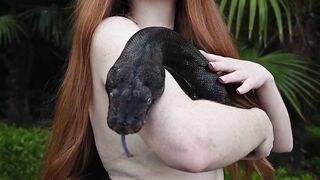 Redhead snake charmer poses nude outdoor