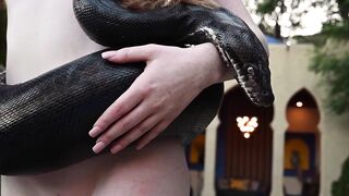 Redhead snake charmer poses nude outdoor