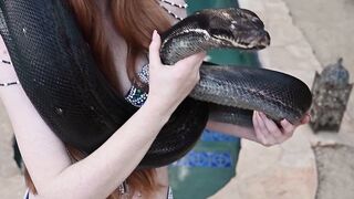 Redhead snake charmer poses nude outdoor