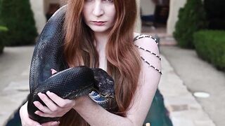 Redhead snake charmer poses nude outdoor