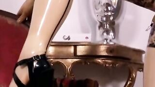Busty masked babe in full latex suit finger fucks herself