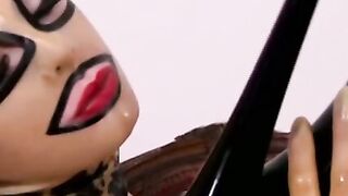 Busty masked babe in full latex suit finger fucks herself