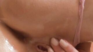 Oiled up blonde teen slips panties to the side for the dildo