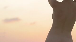 Sensual beauty is showing her naked body while on the beach
