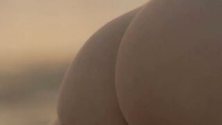 Sensual beauty is showing her naked body while on the beach