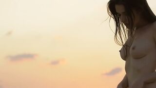 Sensual beauty is showing her naked body while on the beach