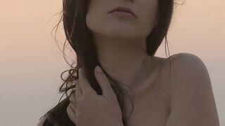 Sensual beauty is showing her naked body while on the beach