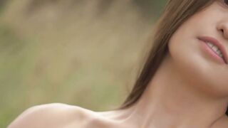 Good looking girl passionately sways her body in a field