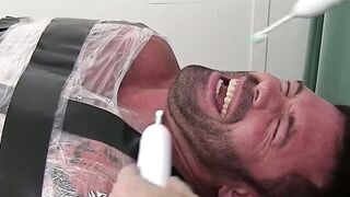 Restrained hunk endures tickling torment from his dom