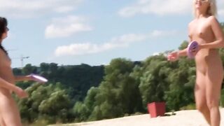 Brune et blonde nues jouent sur une plage naturiste