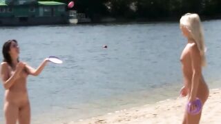 Brune et blonde nues jouent sur une plage naturiste