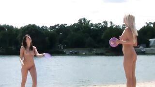 Brune et blonde nues jouent sur une plage naturiste