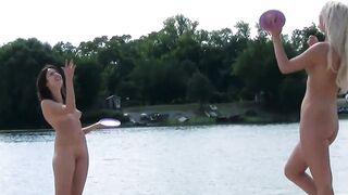 Brune et blonde nues jouent sur une plage naturiste
