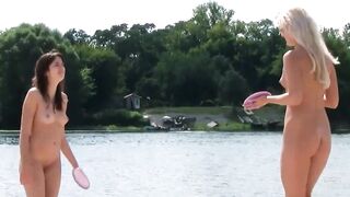 Brune et blonde nues jouent sur une plage naturiste