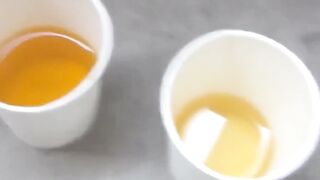 Japanese gal fills cup with yellow pee from hairy pussy