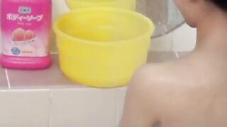 Voyeur films three petite Japanese spraying in a bathhouse