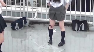 Naughty schoolgirls collect golden showers with an umbrella
