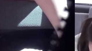 Playful girls stream into a plastic bag in cars backseat