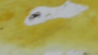 Her long bush gets drenched in the warm stream of her pee