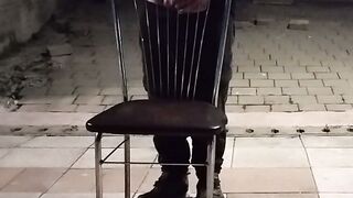 Un baiat se masturbeaza pe un scaun pe faleza pana la ejaculare