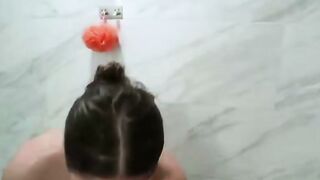 Brunette in Shower with Orange Loofah Gets Naked and Squeezes Breasts