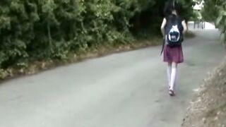 Brunette Schoolgirl in Plaid Skirt Walks Through Woods with Backpack